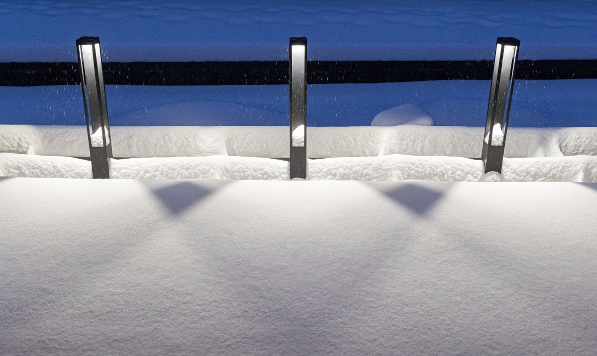 Un gruppo di tre apparecchi Funk Pillar neri sul bordo della terrazza, di fronte alla vasca per le piante. La luce si apre verso il basso.